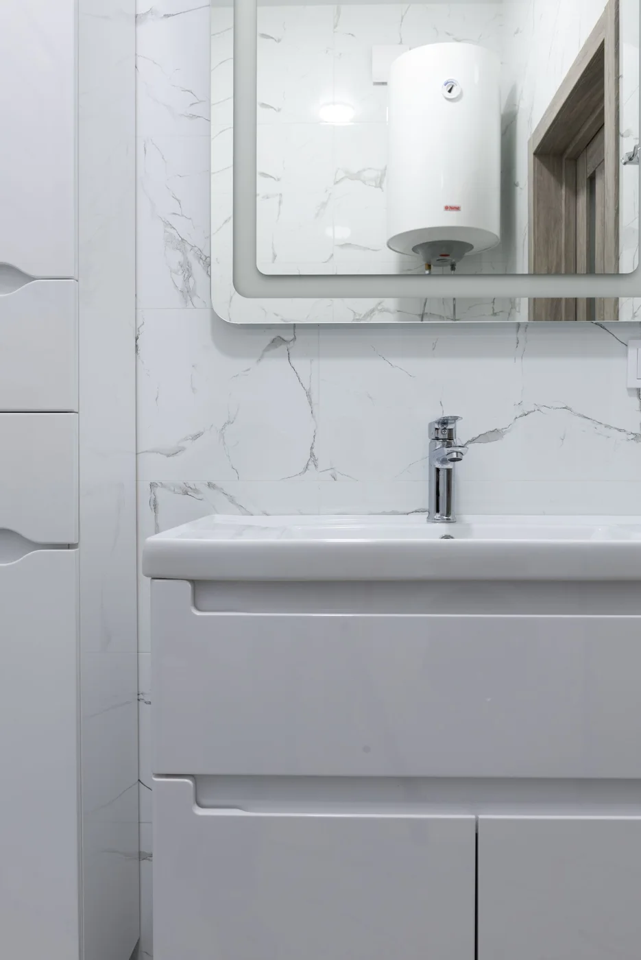 Lavabo et chauffe-eau visible dans le miroir de la salle de bains